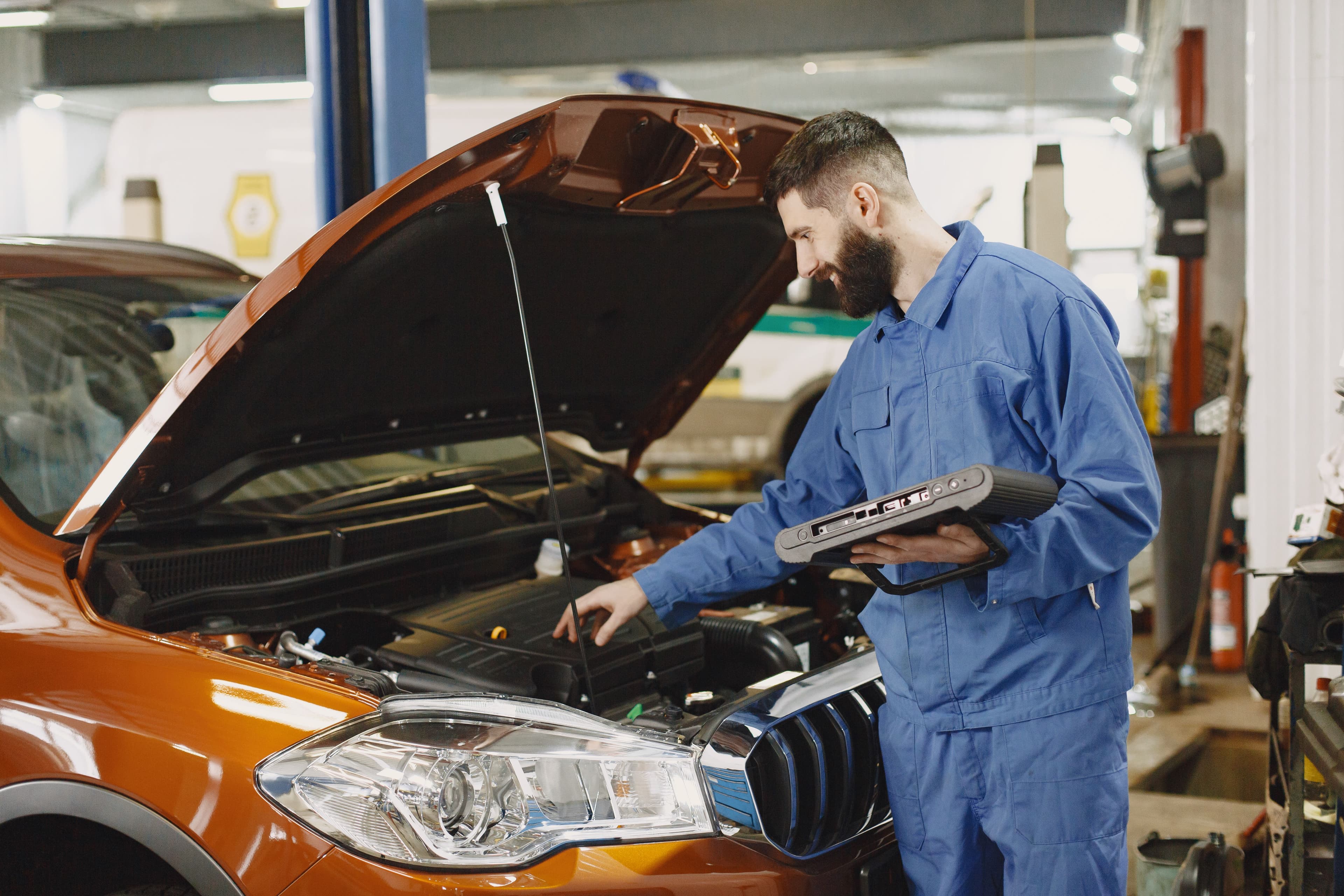 Mechanik provádí počítačovou diagnostiku motoru pomocí diagnostického přístroje